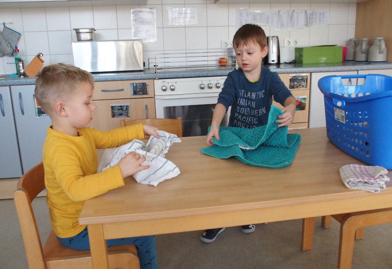 Kinder beim Zusammenlegen von Tüchern