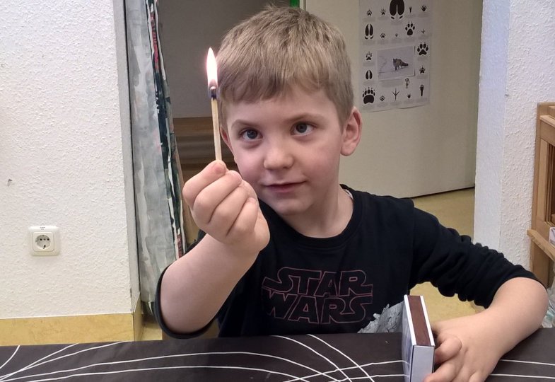 Kind mit einem angezündetem Streichholz
