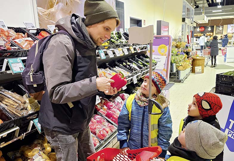 Kinder mit erwachsener Person im Einkaufsladen
