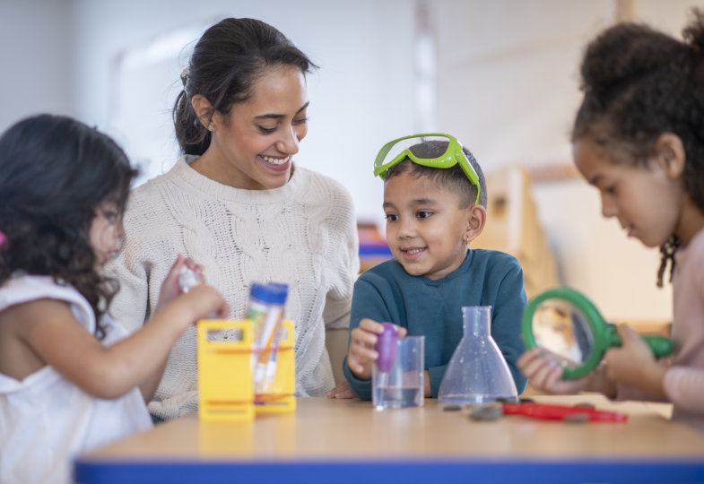 Kinder führen mit einer erwachsenen Person Experimente durch