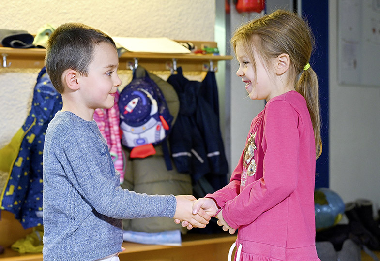Zwei Kinder geben sich die Hand