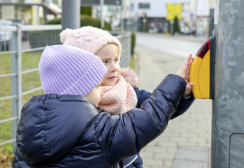 Kinder drücken die Ampel