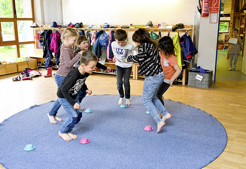 Kinder hüpfen im Kreis im Innenraum
