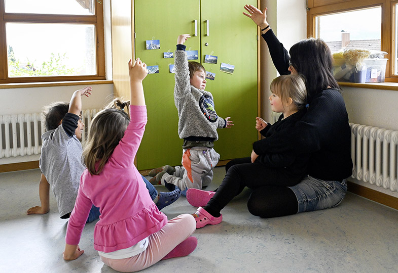 Kinder heben die Hand