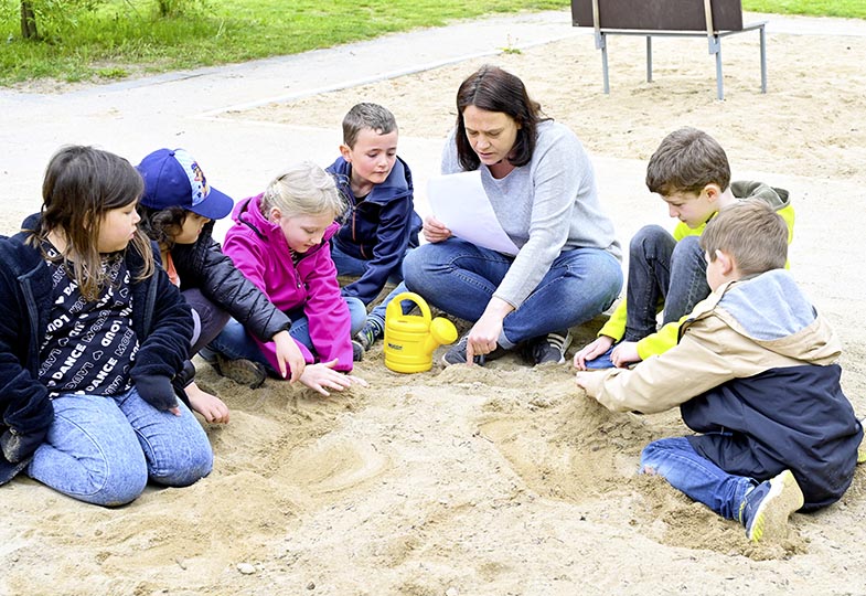 Kinder sitzen im Sand