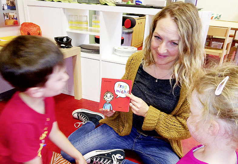 Erwachsene Person zeigt Kinder etwas