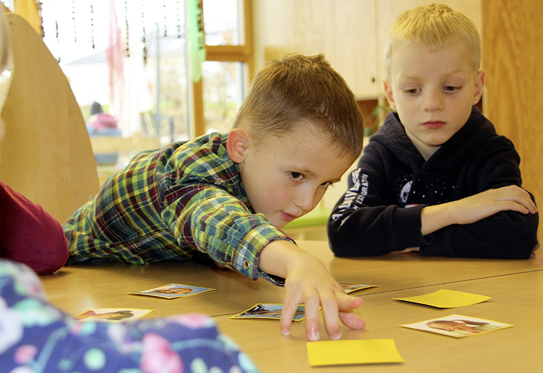 Kinder spielen mit Karten am Tisch