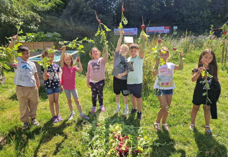 Mehrere Kinder stehen in einem Garten.