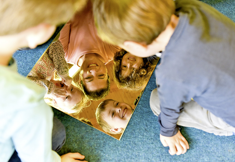 Kinder schauen in einen Spiegel