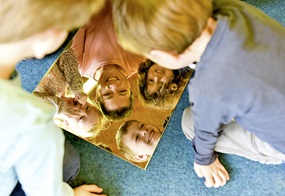 Kinder schauen in einen Spiegel