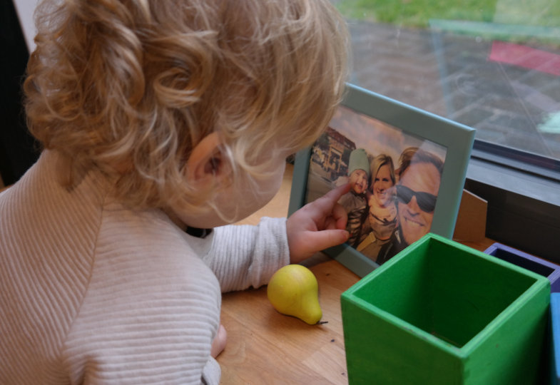Kind zeigt auf Familienfoto