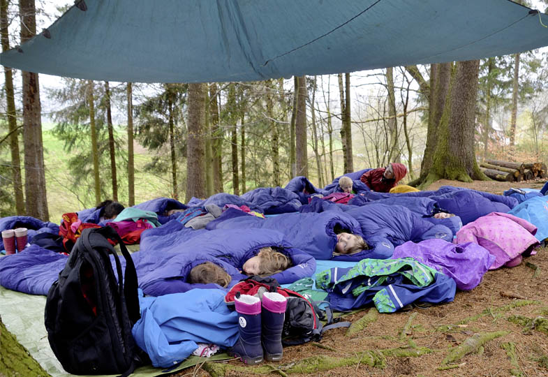 Kinder mit Schlafsäcken im Wald