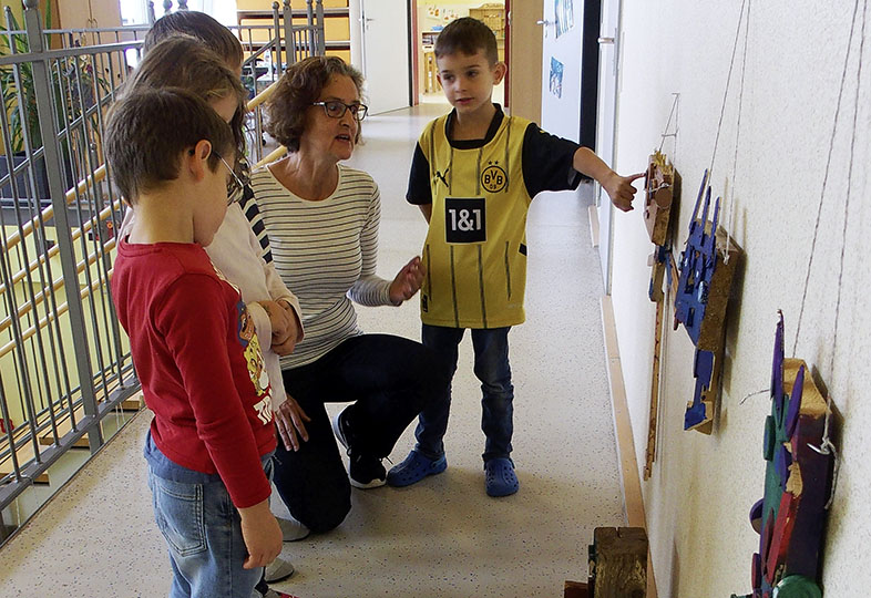 Kinder schauen sich Kunstwerke an der Wand an