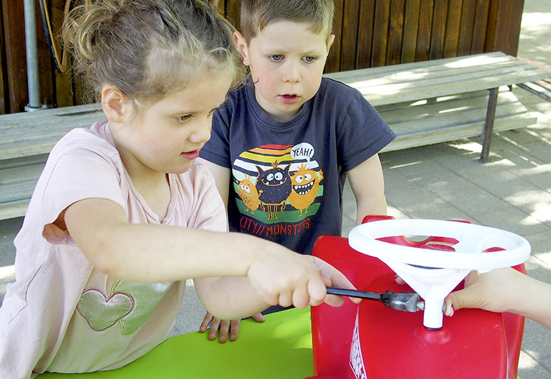 Kinder und ein Bobbycar
