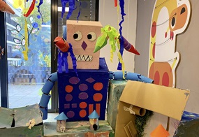 Die Kinder gestalten ein Modell ihrer Zukunftsstadt aus Pappe.