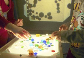 Kinder spielen mit Licht und Schatten