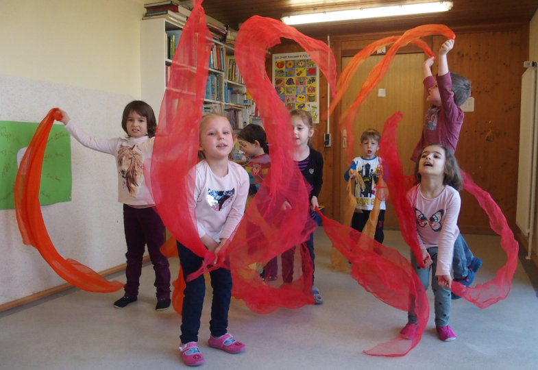 Kinder schwingen mit Tüchern