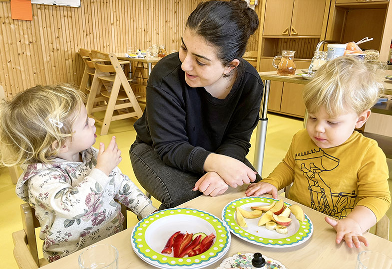 Kinder sitzen am Tisch und essen