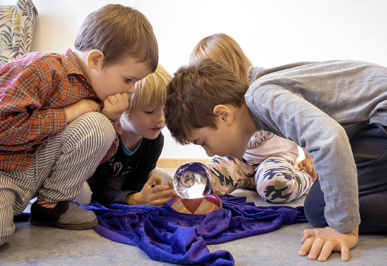 Kinder schauen in eine Wahrsagekugel