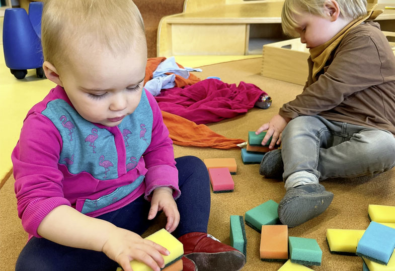 Kinder spielen mit Schwämmen