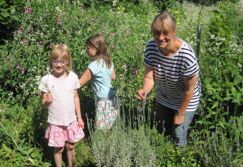 Kinder und erwachsene Person im Garten