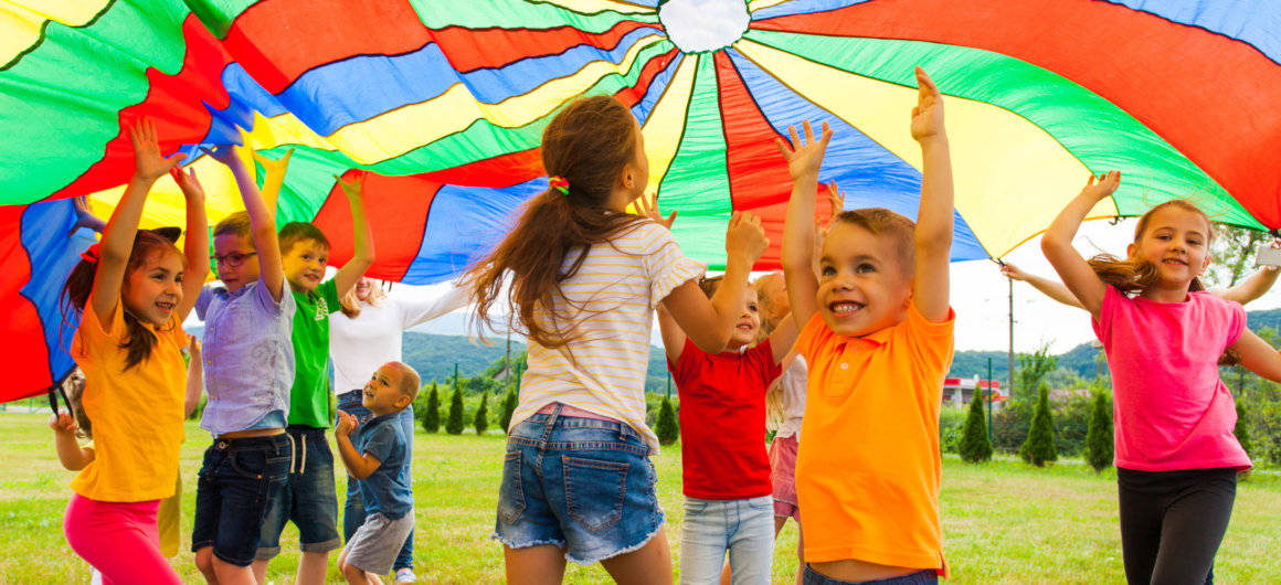 Kinder unter einem großen, bunten Tuch