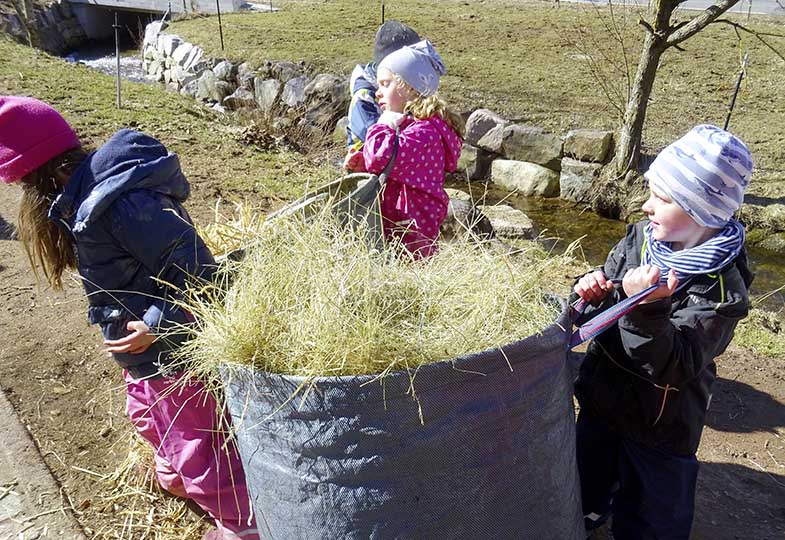 Kinder helfen beim Misten