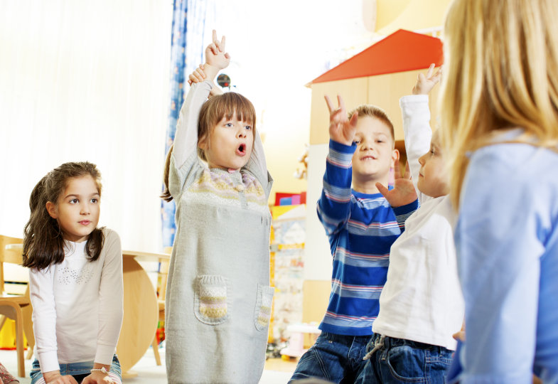 Kinder singen gemeinsam im Kreis
