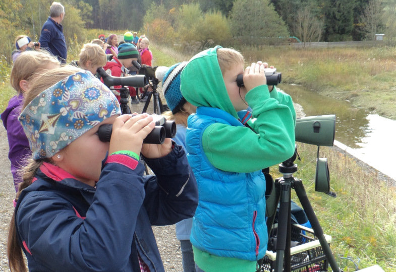 Kinder schauen durch Ferngläser.