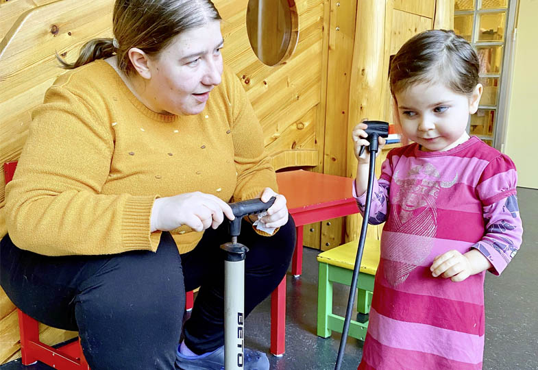 Kind und eine erwachsene Person mit einer Luftpumpe