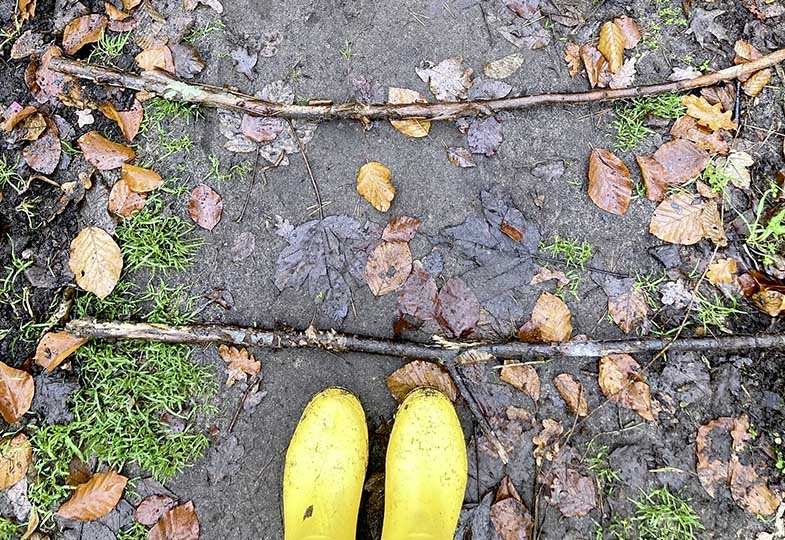 Nasser Waldweg und Gummistiefel