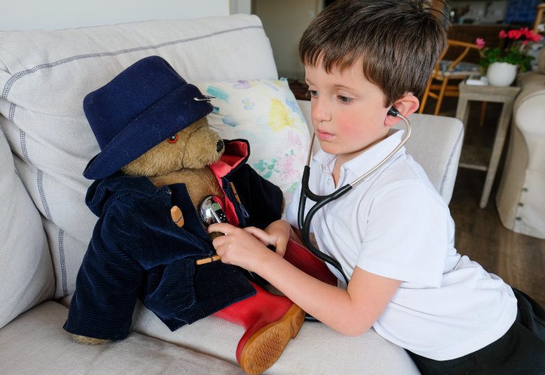 Kind verarztet einen Teddybären