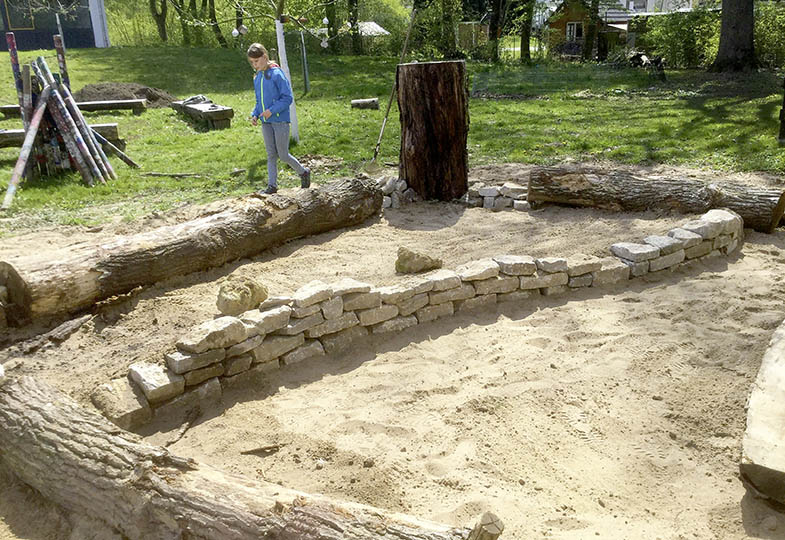 Sand, Steine und Holzstämme