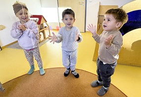 Drei Kinder stehen nebeneinander und klatschen in die Hände.