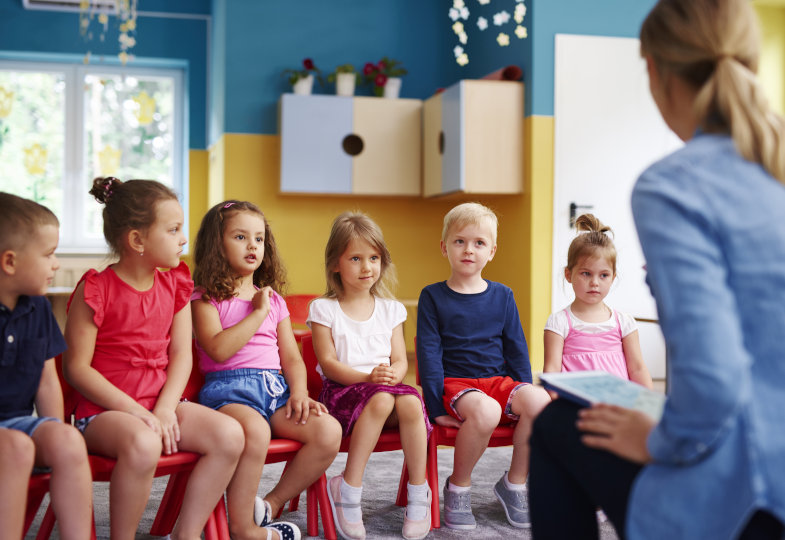 Kinder sitzen im Stuhlkreis