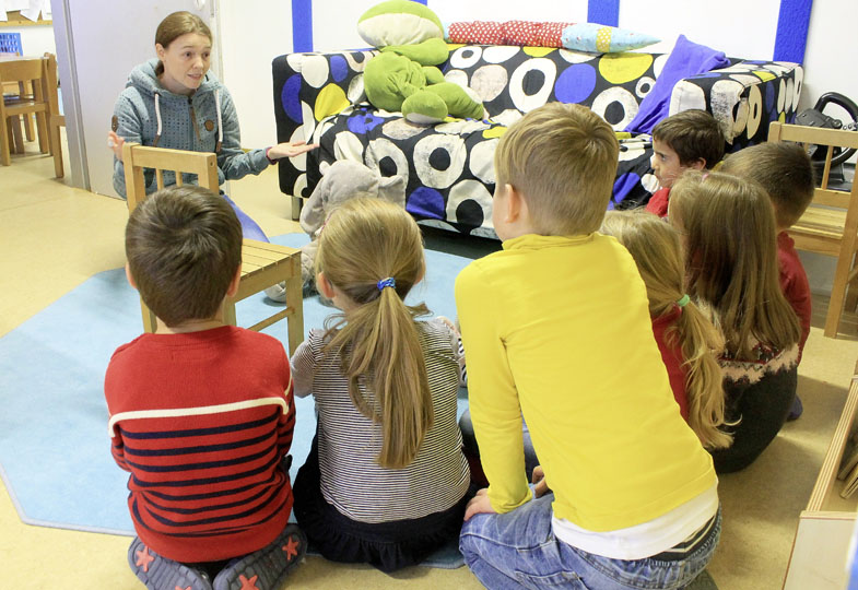 Kinder sitzen im Kreis auf dem Boden