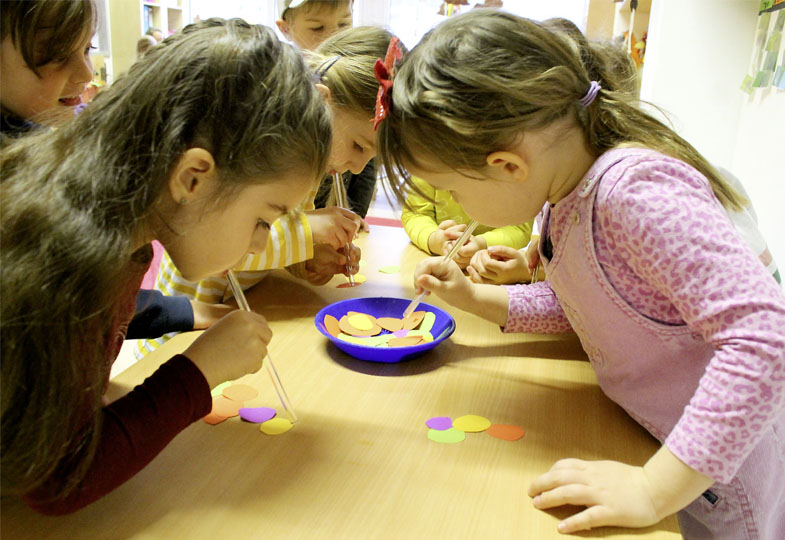 Kinder pusten durch Strohhalme