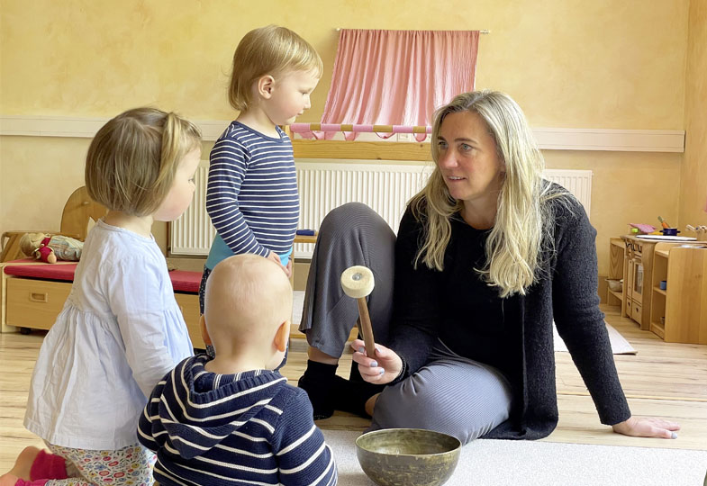 Erwachsene Person, drei Kinder und eine Klangschale