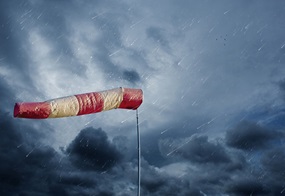 Eine rotweiße Windhose weht bei stürmischem Regenwetter im Dunkeln.