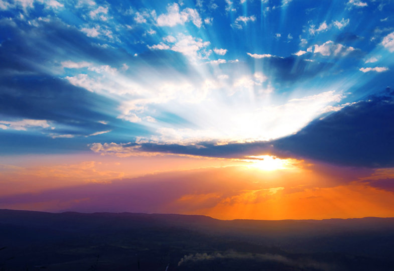 Ein strahlender Sonnenuntergang taucht den Himmel in leuchtende Blau-, Orange- und Violetttöne.