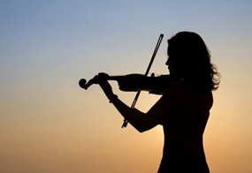 Eine Frau spielt im Gegenlicht Geige