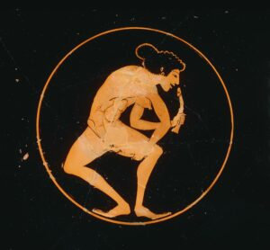 Foto einer nackten Griechin, die in jeder Hand einen Phallus hält