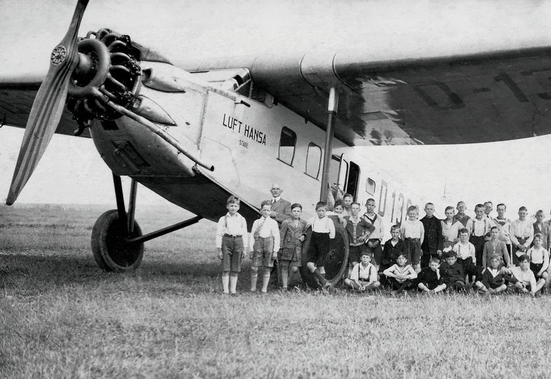 Eine Gruppe von Jungs steht vor einem Flugzeug