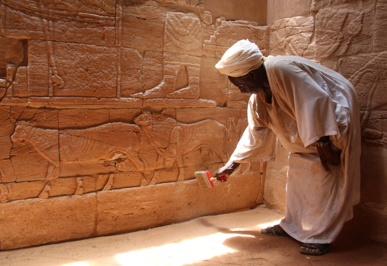 Ein Wächter beim Reinigen von Reliefs in Musawwarat as-sufra, Sudan