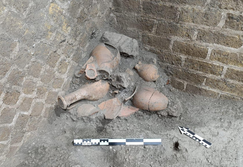 Mehrere antike Keramikgefäße liegen in einer Ecke.