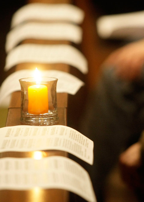 Brennende Kerzen auf einer Kirchenbank