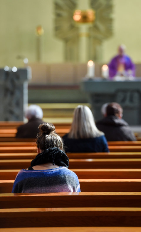 Menschen in Kirchenbänken