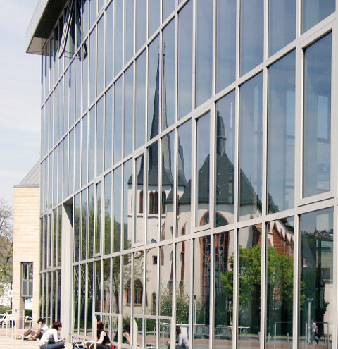 Ein spätgotischer Kirchenbau spiegelt sich in einer postmodernen Glasfassade