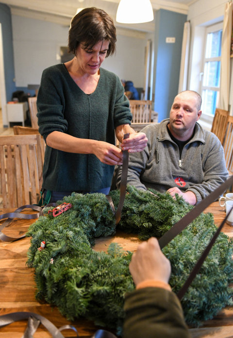 Ein Adventskranz wird mit einem Band umwickelt