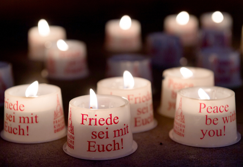 Brennende Kerzen mit aufgedrucktem Friedenswunsch